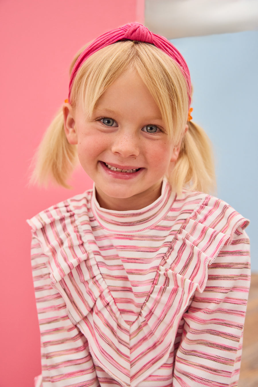 Model can be seen wearing a knit long sleeve stripe  top that features a v-ruffle detail down the center of the shirt for an elevated look. 
