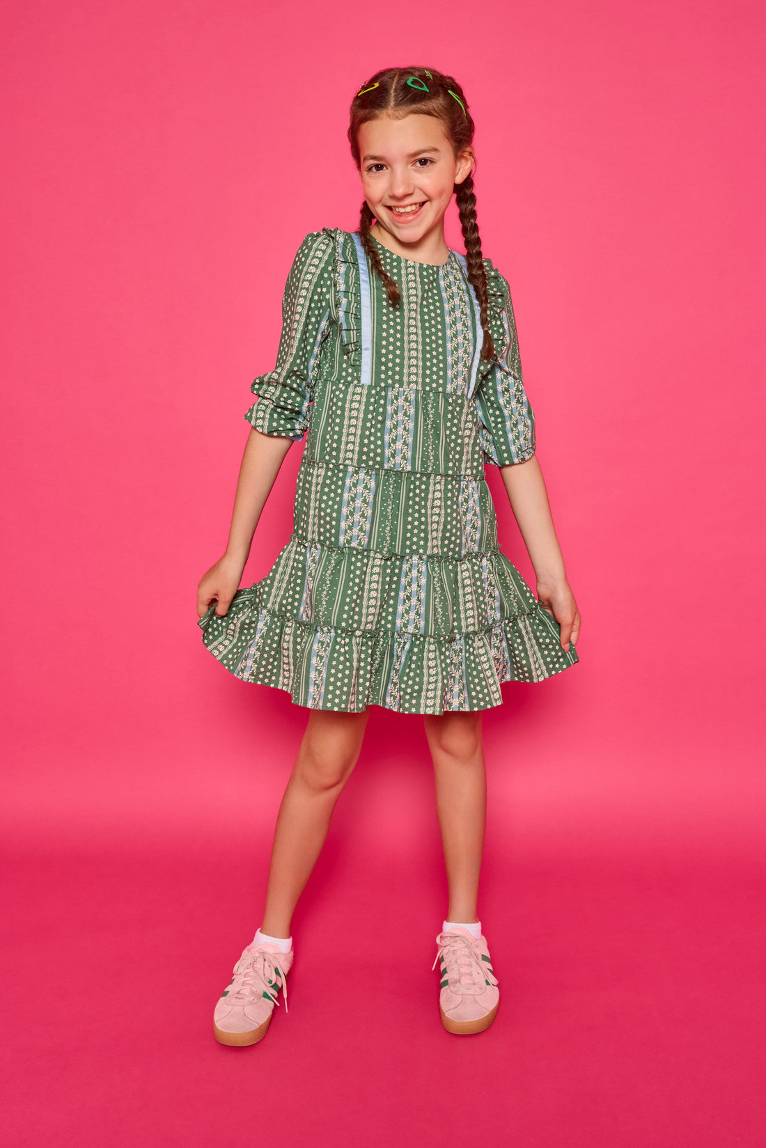 Model can be seen wearing woven dress in a green/blue/white floral. Dress features four tier detail to elevate the dress.