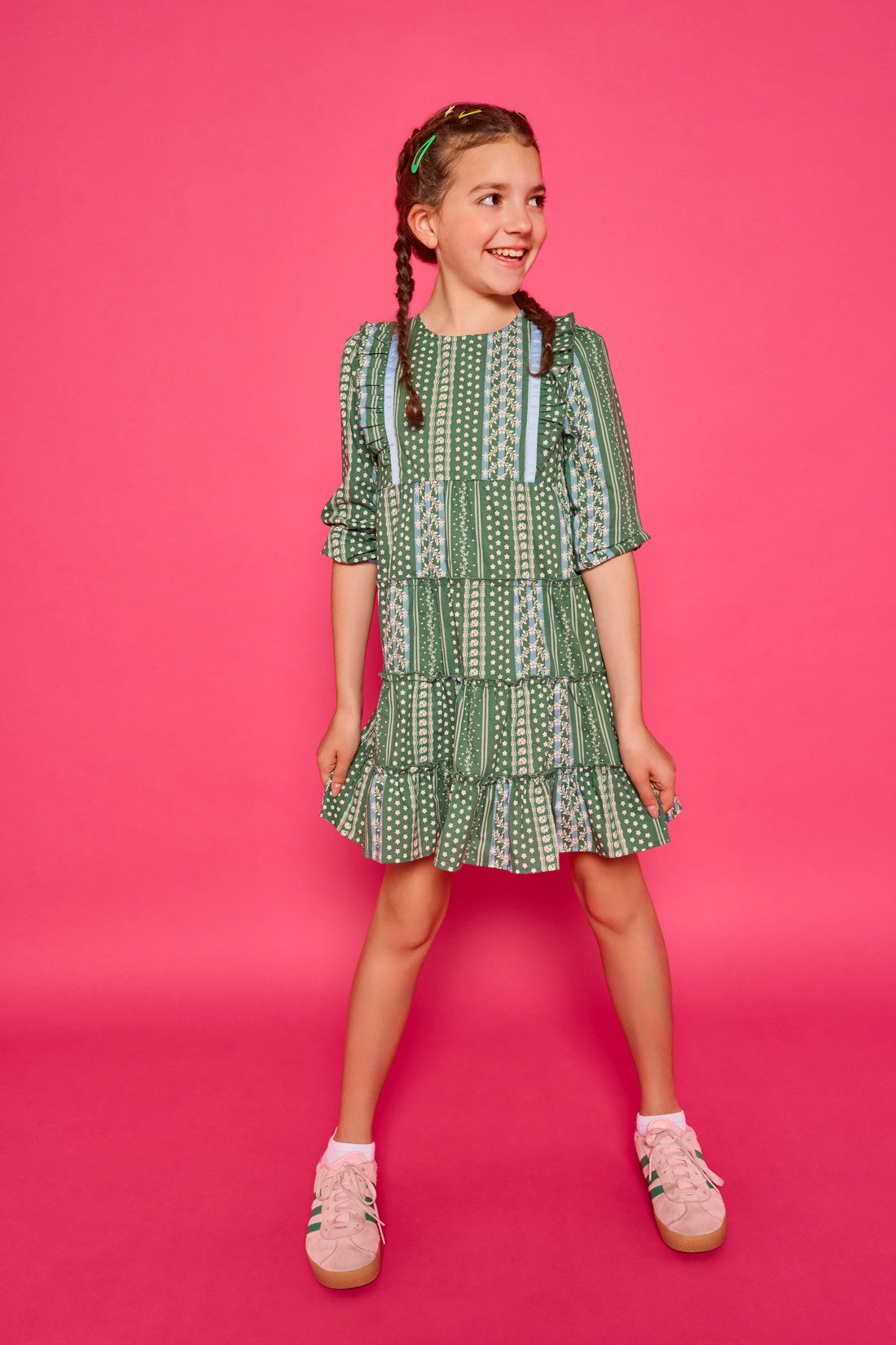 Model can be seen wearing woven dress in a green/blue/white floral. Dress features four tier detail to elevate the dress.