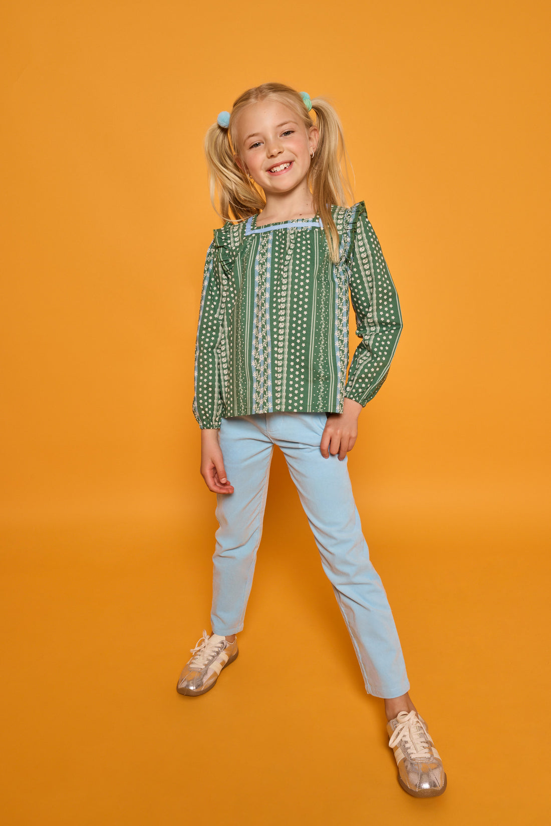 Model can be seen wearing woven long sleeved top with square neckline in a blue/white/green floral print. Paired back perfectly with the light blue corduroy pants to complete the look. 