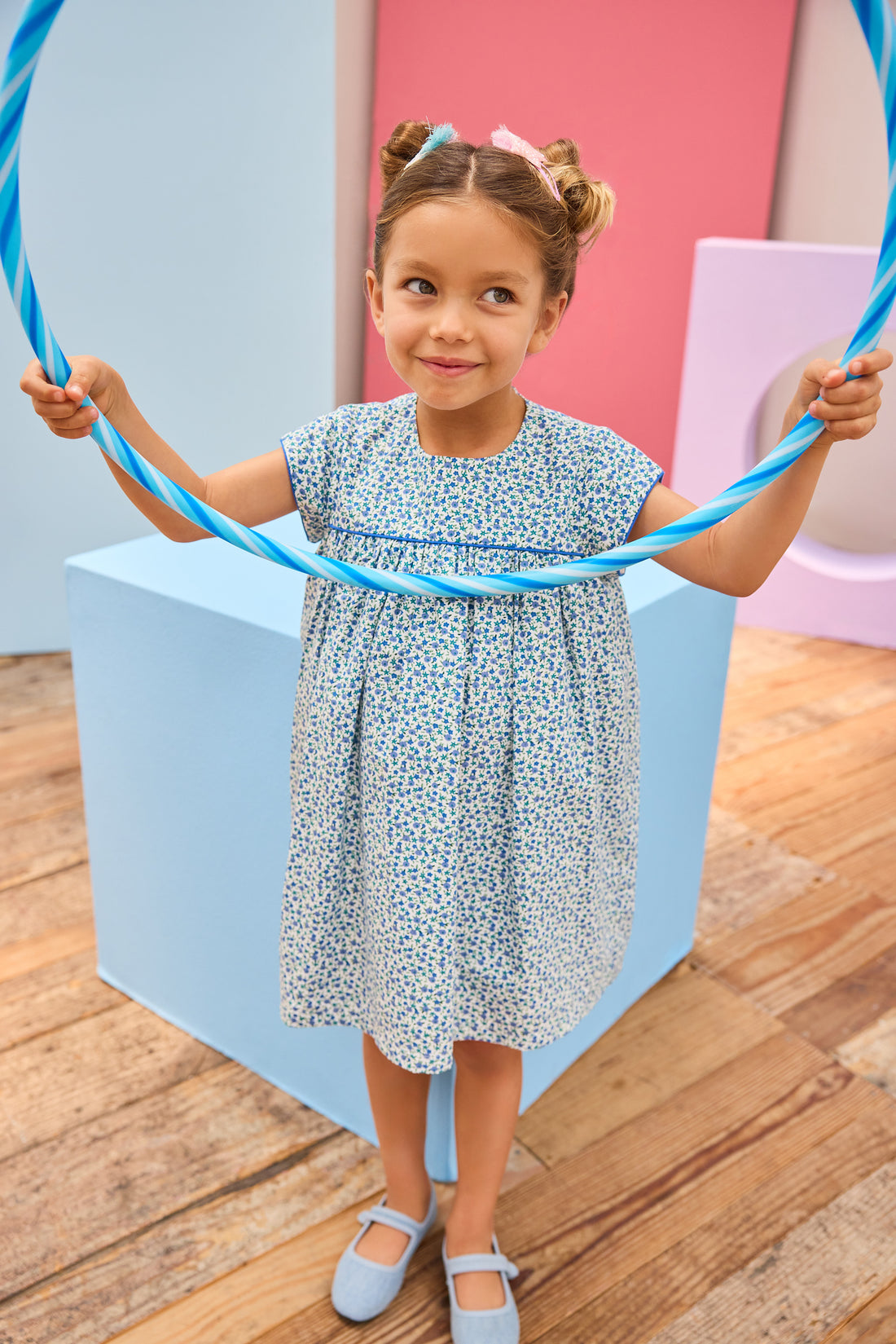 Model can be seen wearing a woven short sleeve dress in a gorgeous blue floral print that features button closures along back and blue trim detail across bust and along sleeves for an elevated look. 