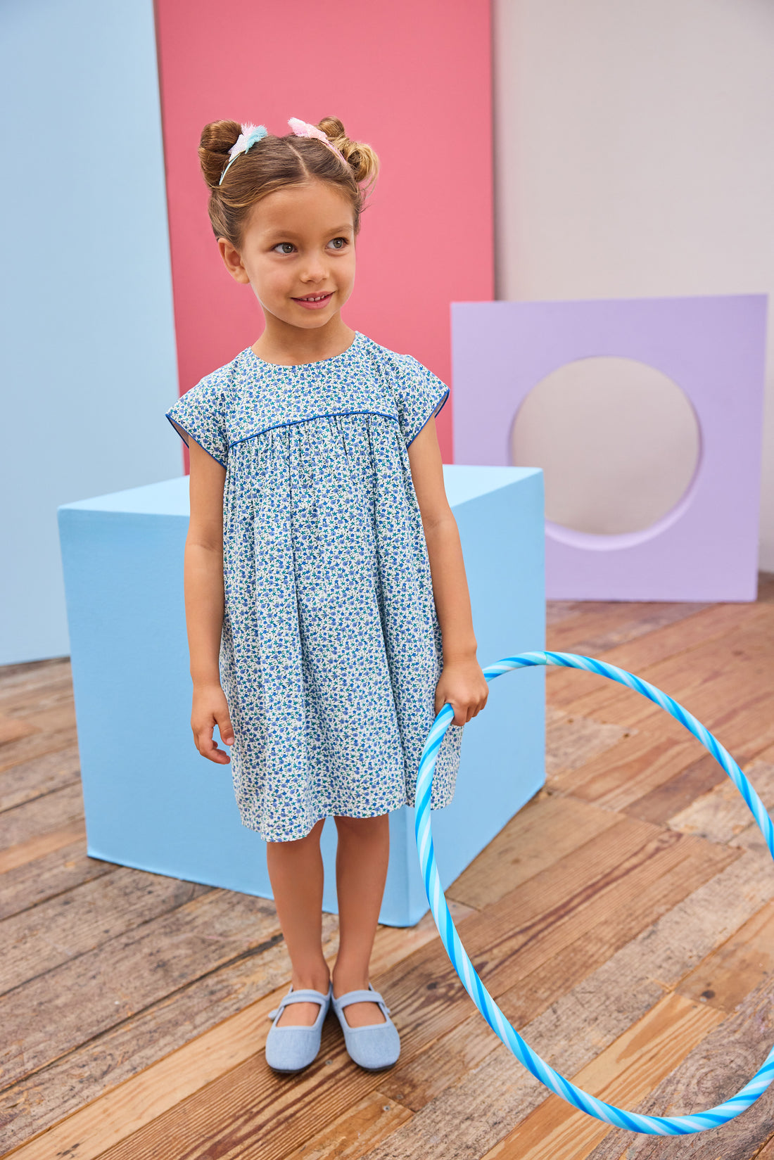 Model can be seen wearing a woven short sleeve dress in a gorgeous blue floral print that features button closures along back and blue trim detail across bust and along sleeves for an elevated look. 