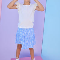 Model can be seen wearing a blue knit skort with a white floral design. Skort features an elastic waistband and built in shorts for a comfy but secure fit. Skort pairs back perfectly with a white knit t-shirt that features eyelet detail on the angel sleeves. 