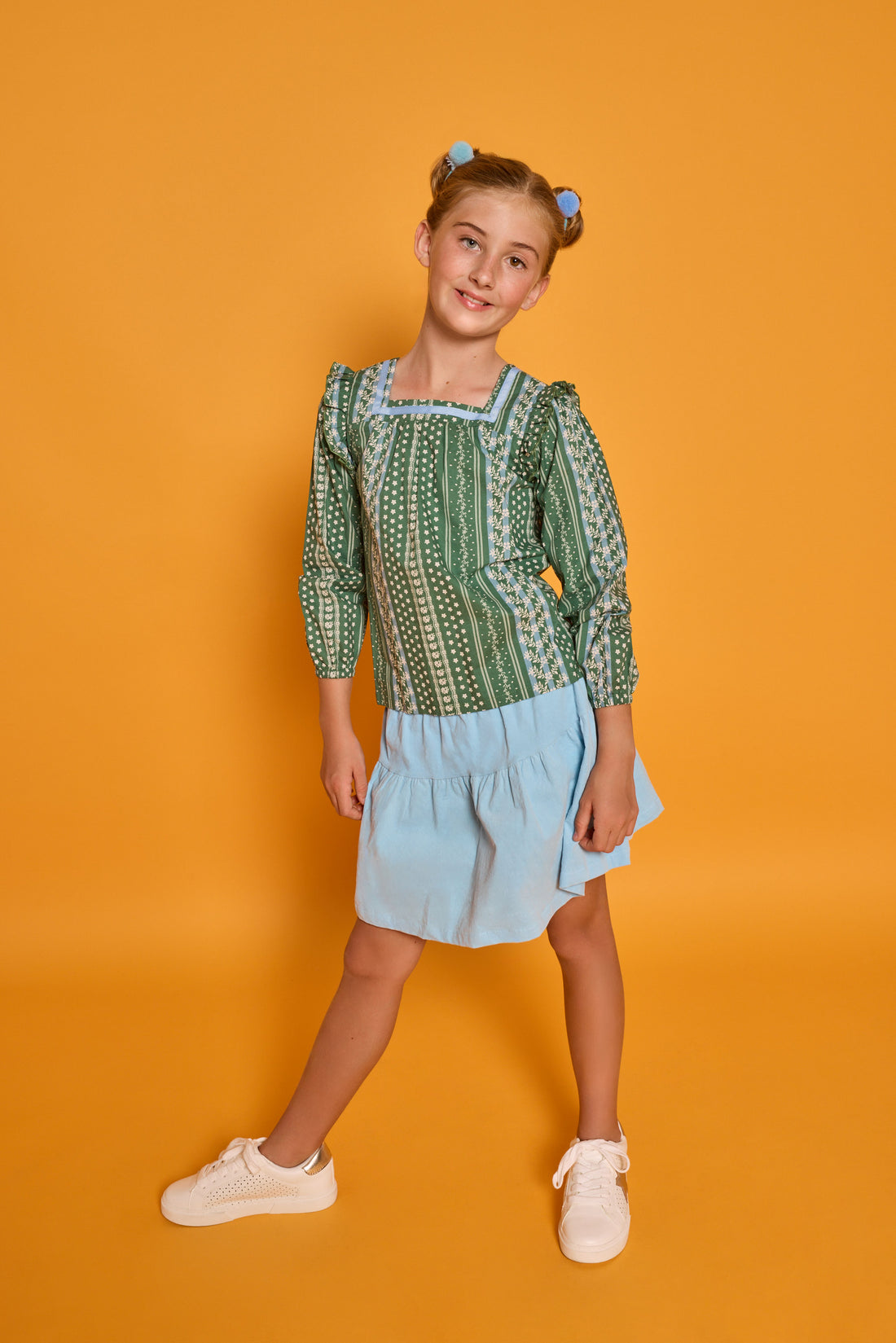 Model can be seen wearing woven long sleeved top with square neckline in a blue/white/green floral print. Paired back perfectly with the light blue corduroy skort to complete the look. 