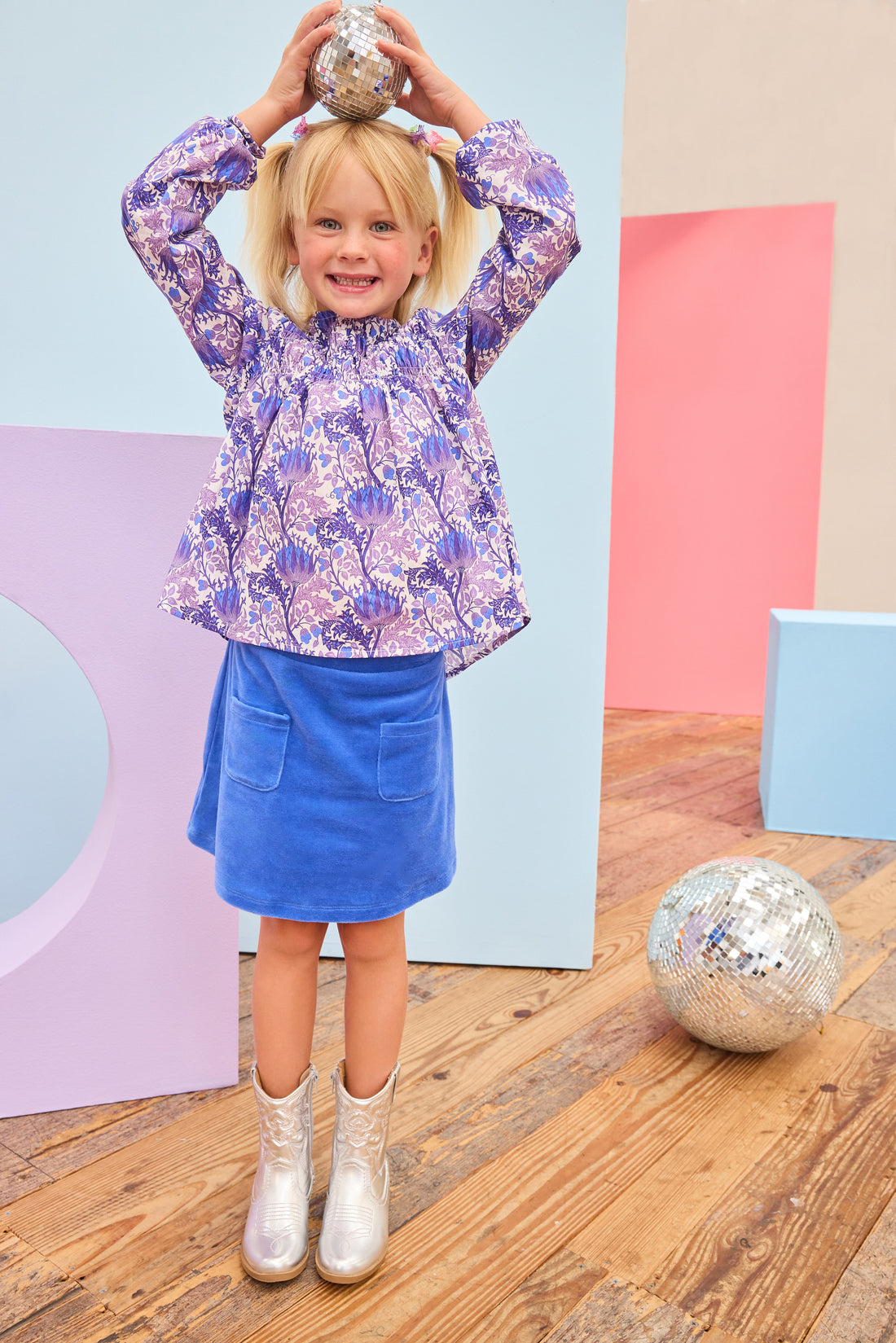 Model can be seen wearing a royal blue velour skort that features an elastic waistband, built in shorts, and two functioning pockets in the front of skort. Pair skort back with purple/blue/white floral top to complete the look. 
