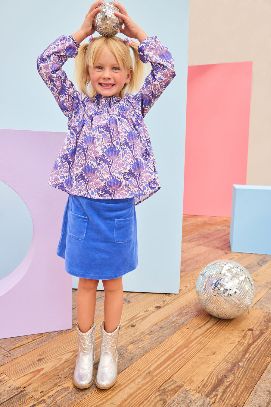 Model can be seen wearing a royal blue velour skort that features an elastic waistband, built in shorts, and two functioning pockets in the front of skort. Pair skort back with purple/blue/white floral top to complete the look. 