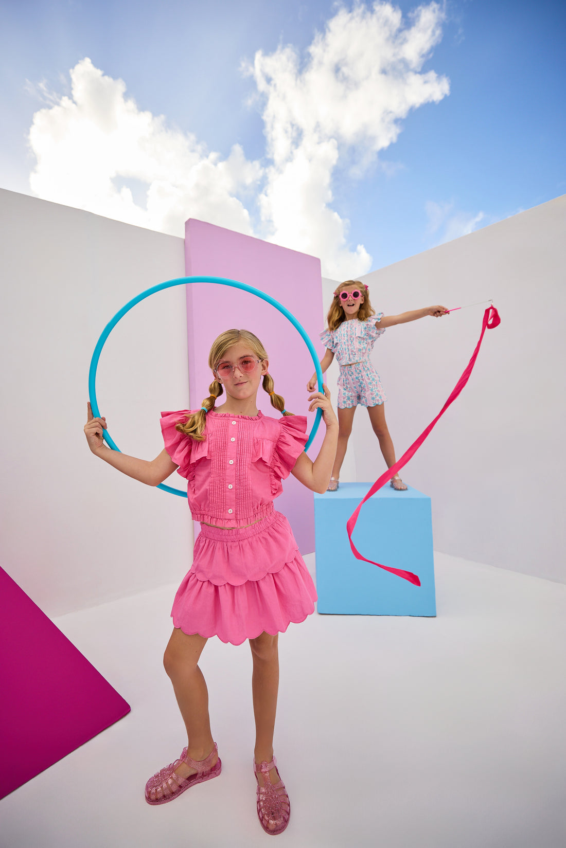 Model can be seen wearing woven hot pink two tiered skort. Skort features elastic waistband and built in shorts for a secure fit. Skort pairs back perfectly with woven hot pink top in same fabric to complete the look. 