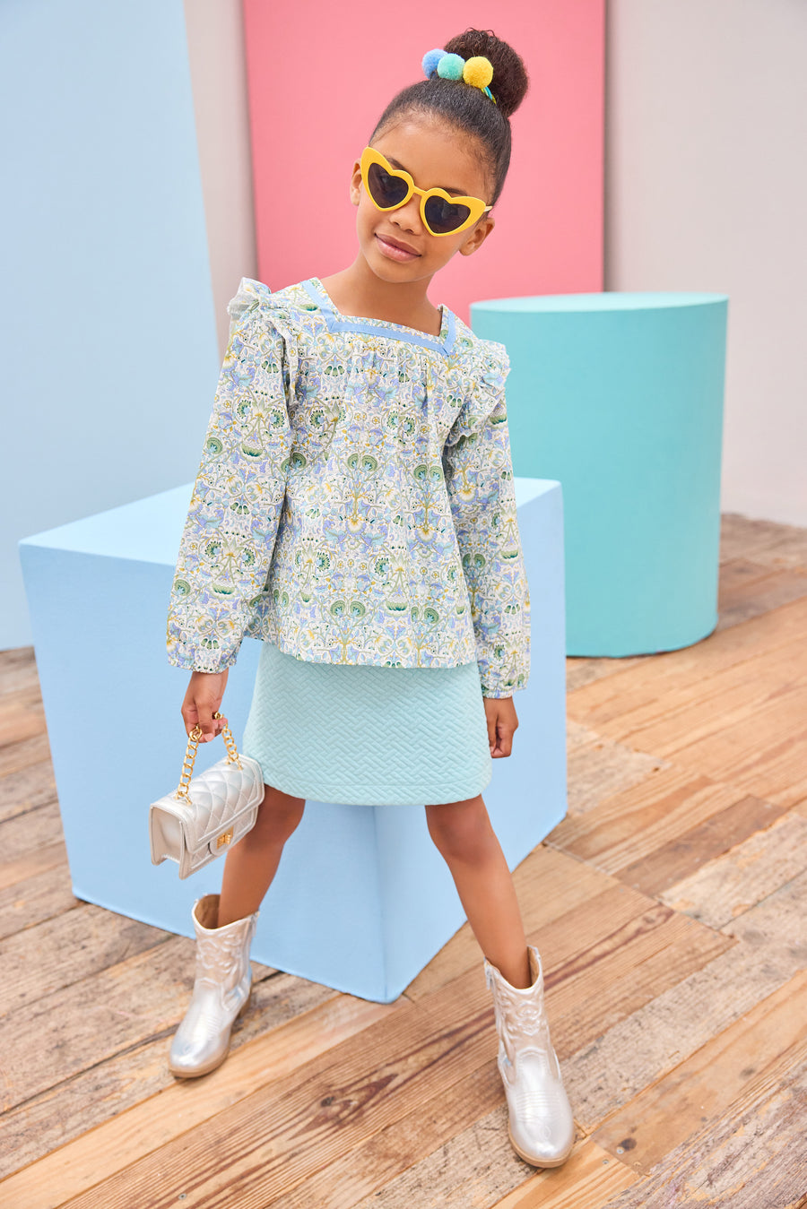 Model can be seen wearing an aqua quilted knit skort in a trellis pattern for a soft an elevated look, which pairs back perfectly with the long sleeve floral aqua/blue/yellow/green floral top.
