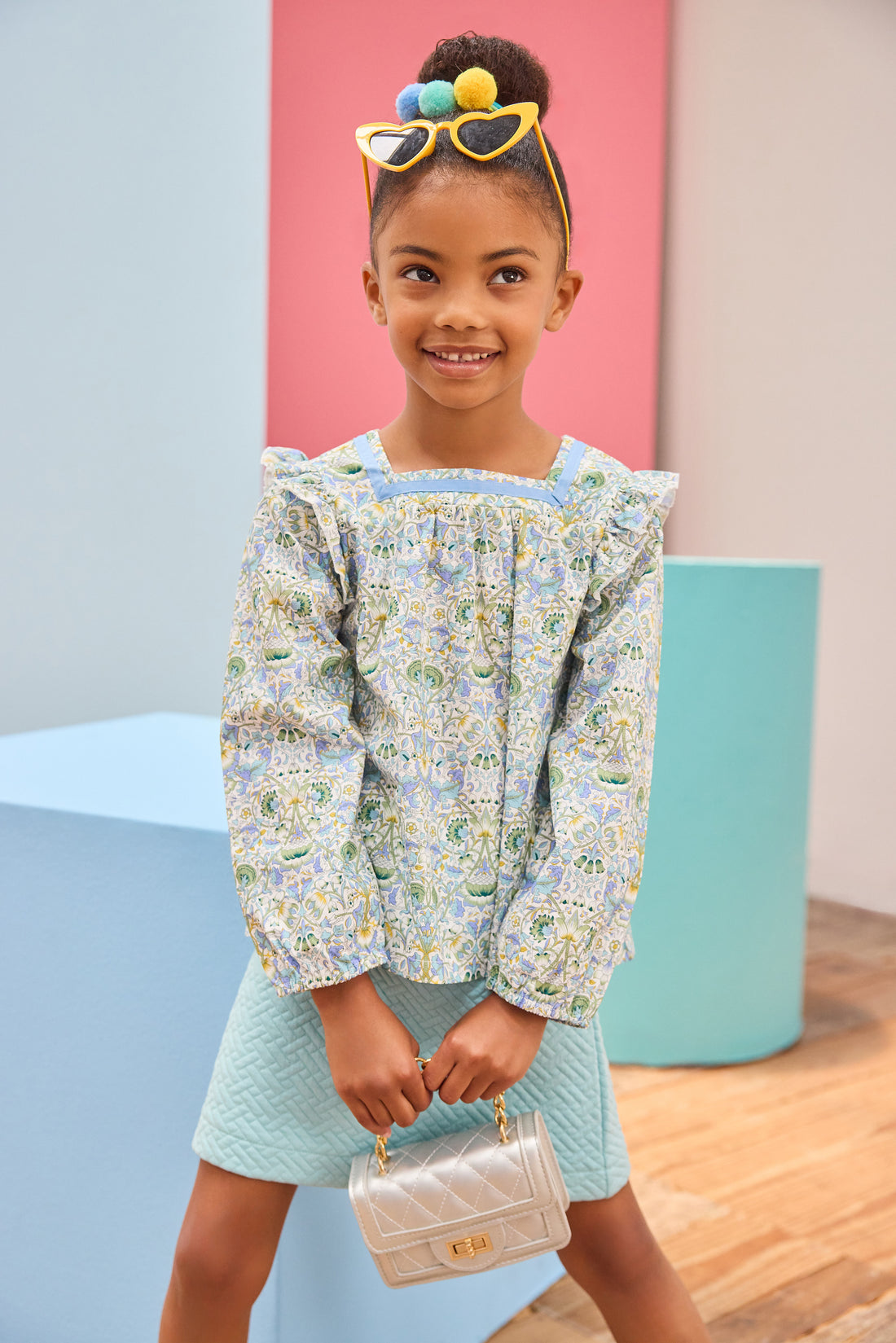 Model can be seen wearing an aqua quilted knit skort in a trellis pattern for a soft an elevated look, which pairs back perfectly with the long sleeve floral aqua/blue/yellow/green floral top.