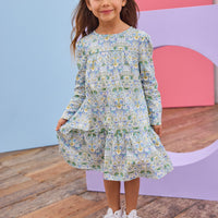Model can be seen wearing woven long sleeve dress in a beautiful aqua/blue/green/yellow floral print.