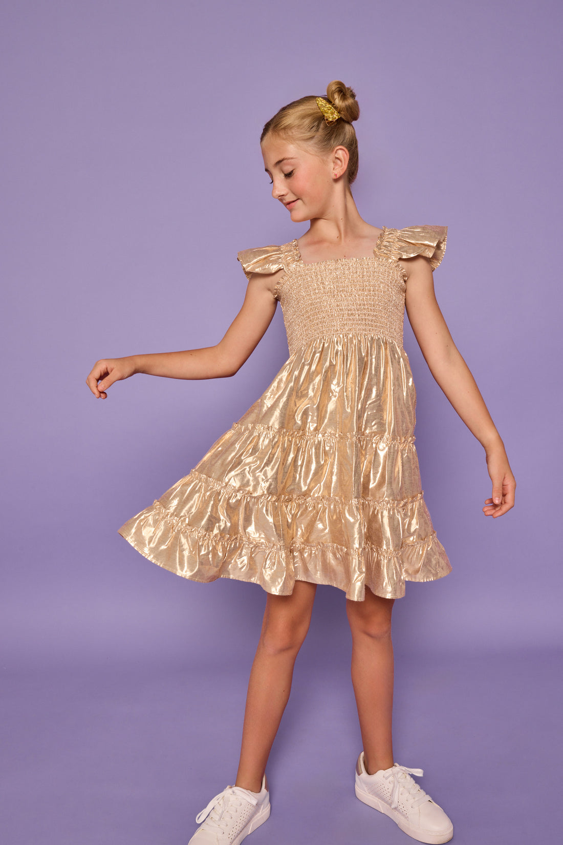 Model can be seen wearing gold metallic lurex that features smocking across bust and angel sleeve sleeves for an elevated look. 