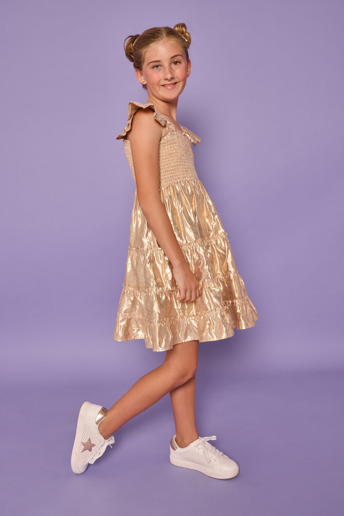 Model can be seen wearing gold metallic lurex that features smocking across bust and angel sleeve sleeves for an elevated look. 