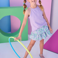 Model can be seen wearing a lavender halter tank top that features button closure along back and is made of a stretchy knit fabric. Top pairs back perfectly with tiered skort in the purple/aqua/green floral to complete the look. 