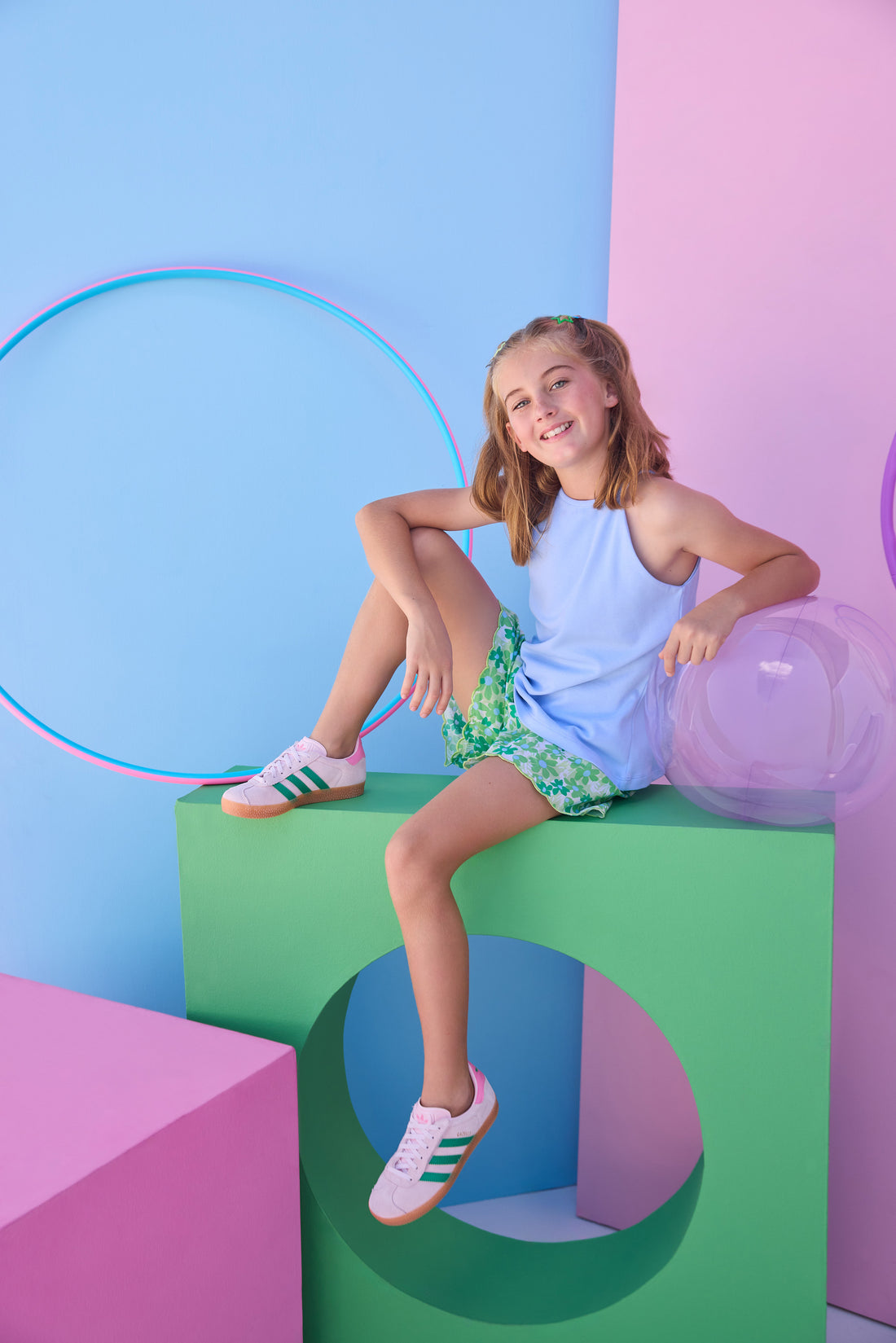 Tween model can be seen wearing a knit light blue halter tank top that features button closure along back and made of a soft comfy material. Top pairs back perfectly with woven shirred shorts in a beautiful green/light blue print to complete the look. 