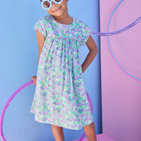 Model can be seen wearing aqua/purple/green floral print that features button closure along back neckline and a beautiful hot pink trim along bust and sleeves to elevate the look. 