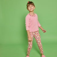Model can be seen wearing a pink striped knit long sleeve tee with a pink/red/yellow floral ruffle detail along neckline that pairs back perfectly with the print of the knit leggings paired back with it. 