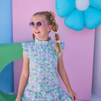Model can be seen wearing a woven aqua/purple floral top that features angel sleeve details, high ruffle neckline, and button closure on back for a comfy but secure fit. Matches back perfectly with the tiered skort in the same floral print to complete the look.