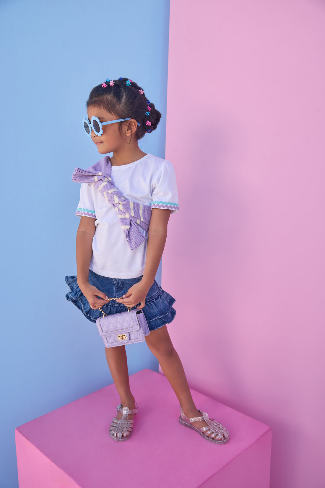 Model can be seen wearing a denim mini skirt that features ruffle detail and button closure for a secure fit. Pair skirt back with a ric rac tee to complete the look. 