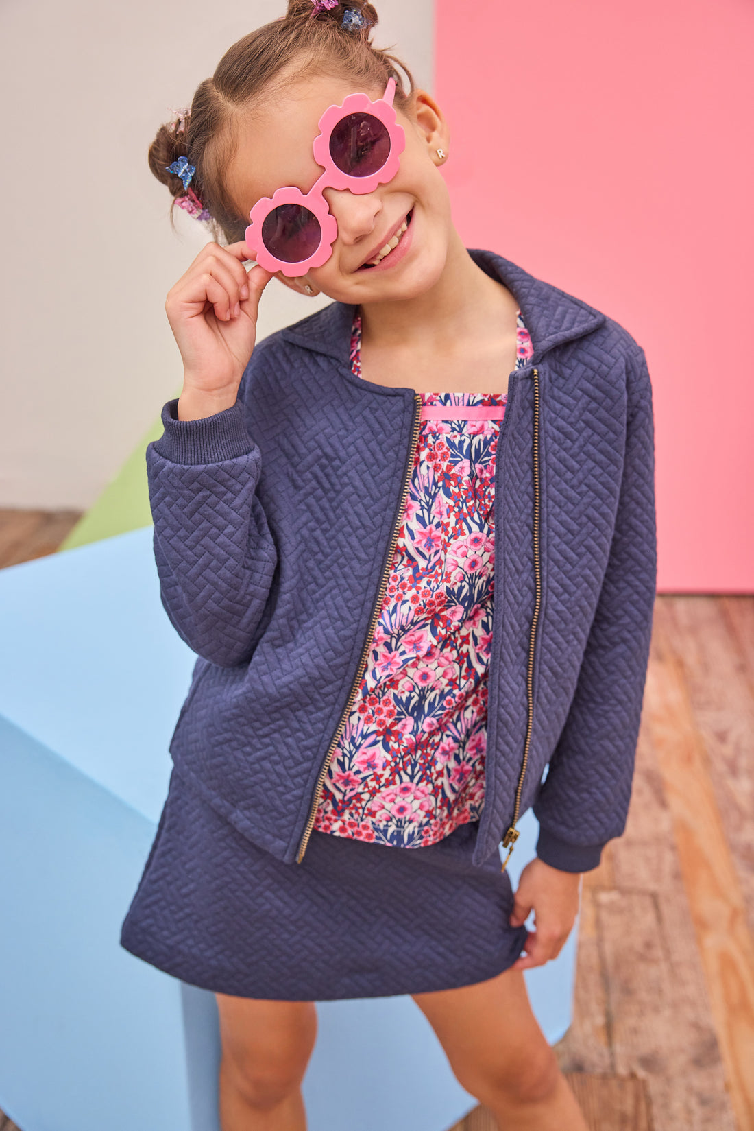 Model can be seen wearing a quilted knit jacket that features pockets on the sides and a gold zipper for an elevated look. Pair back perfectly with the matching skort in the same fabric and color and a long sleeve navy/pink/cranberry floral shirt to complete the look. 