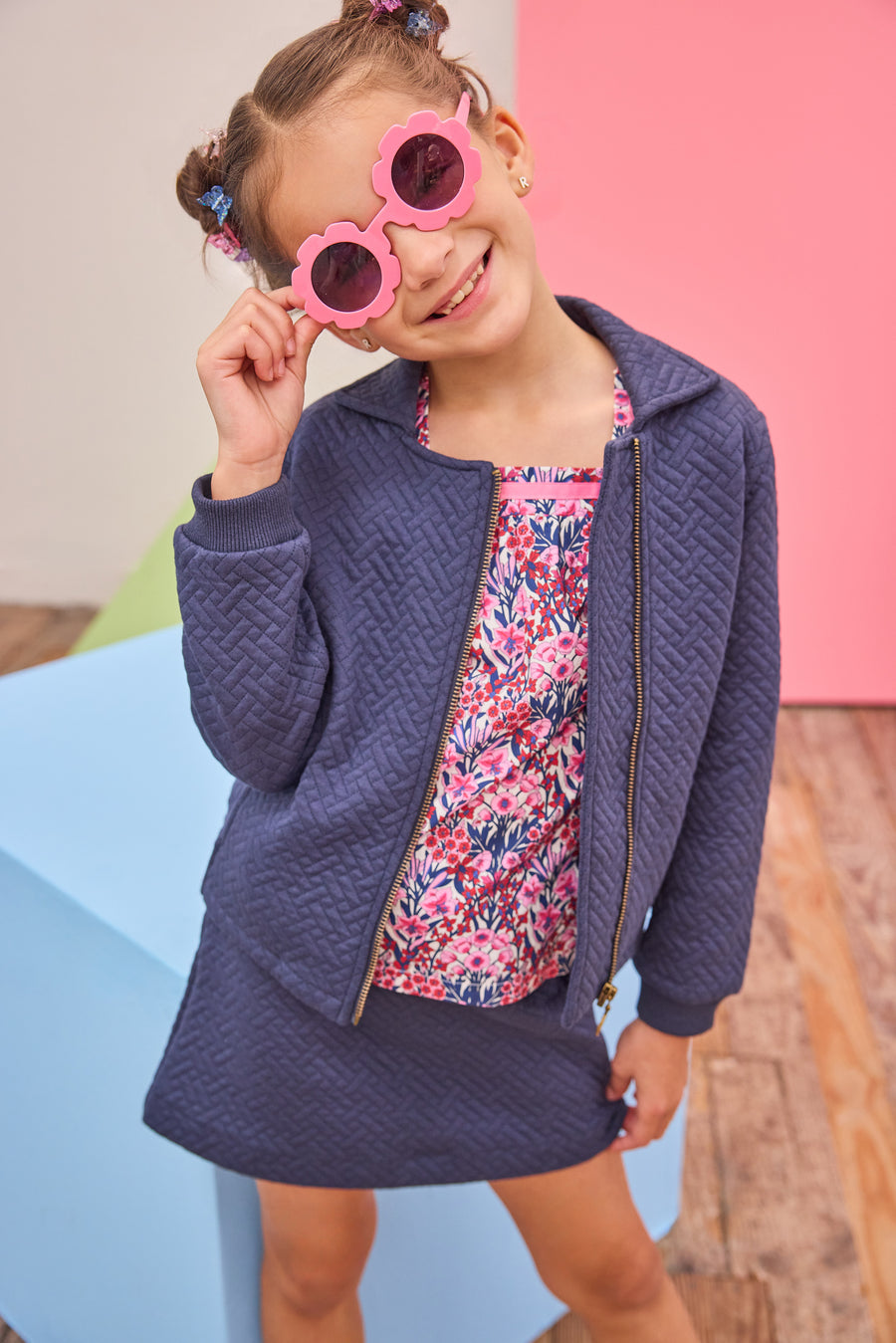 Model can be seen wearing a quilted knit jacket that features pockets on the sides and a gold zipper for an elevated look. Pair back perfectly with the matching skort in the same fabric and color and a long sleeve navy/pink/cranberry floral shirt to complete the look. 