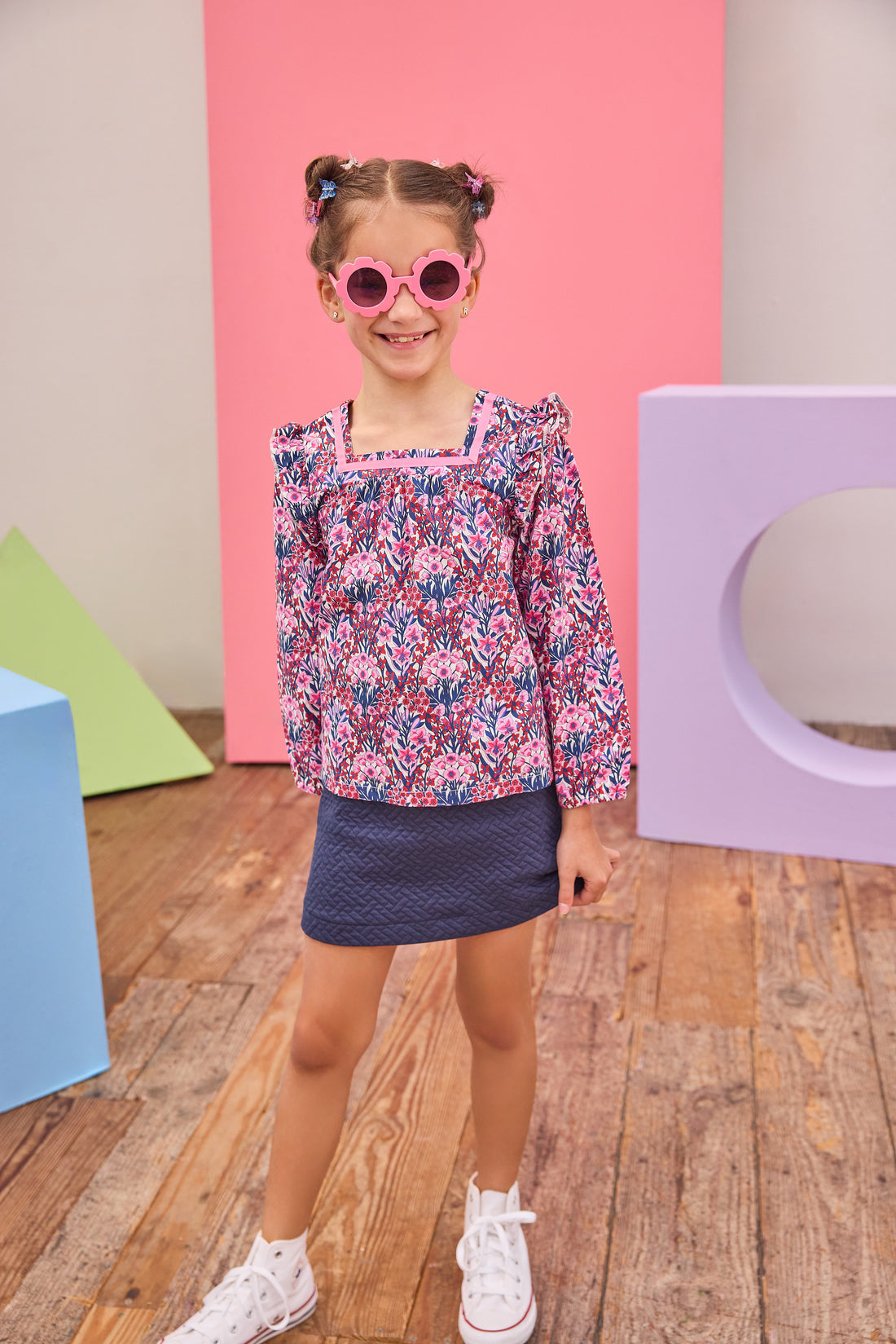 Model can be seen wearing a navy quilted knit skort that features an elastic waistband and built in shorts for a relaxed but secure fit. Skort pairs back perfectly with long sleeve woven top in navy/pink/cranberry floral print to complete the look. 