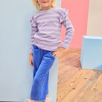 Model can be seen wearing knit ribbed stripe shirt in a fun purple/blue/white stripe that features angel sleeve detail at top of sleeves. Top pairs back perfectly with knit velour pants in royal blue to complete the look. 