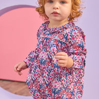 Baby girl can be seen wearing a woven bubble in a gorgeous pink/navy/cranberry color floral that features a ruffle neckline and snap closure for easy put on/pull off access. 