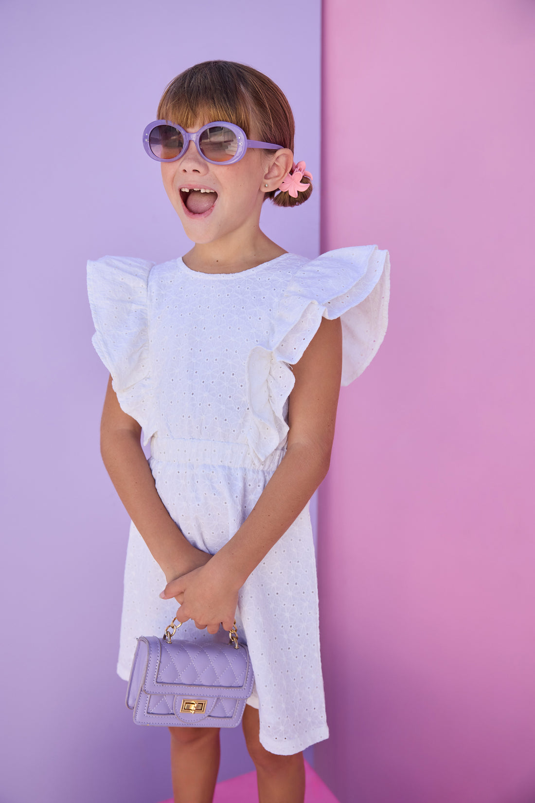 Model can be seen wearing a white woven embroidery material. Dress features big angel sleeve detail and almost full open back for an elevated look. 