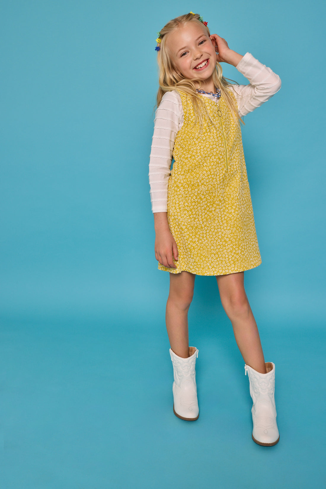 Model can be seen wearing a jumper in a yellow/white floral print. Jumper is made of a corduroy material and has a quarter zip zipper down the front. Paired nicely with our essential scallop tee to complete the look. 