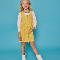 Model can be seen wearing a jumper in a yellow/white floral print. Jumper is made of a corduroy material and has a quarter zip zipper down the front. Paired nicely with our essential scallop tee to complete the look. 