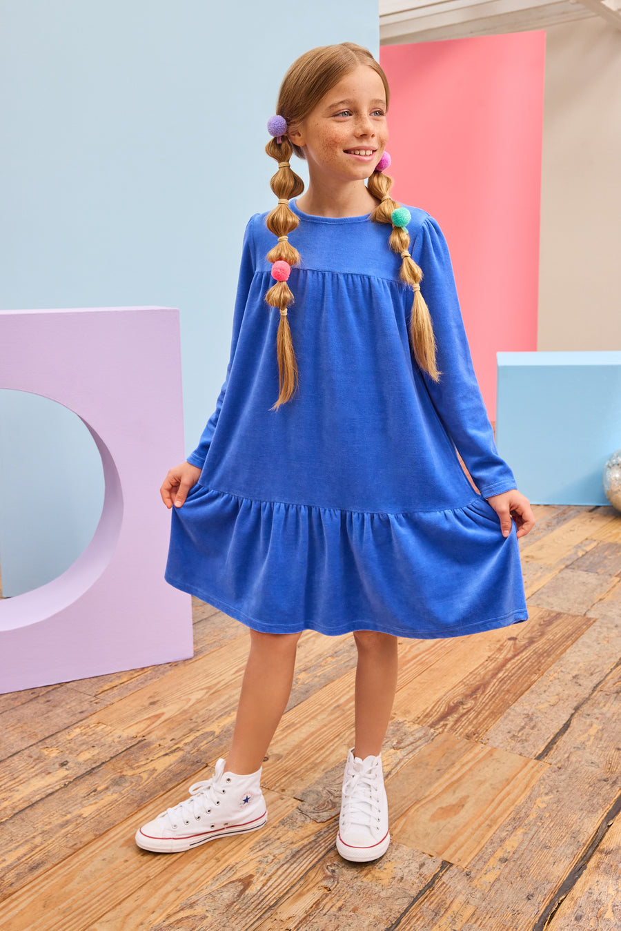 Model can be seen wearing a long sleeve royal blue velour dress which is made of a soft and stretchy velour and also features ruching along top tier and bottom tier of dress for an elevated look. 