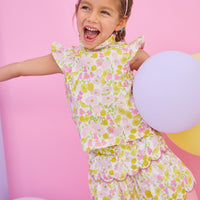 Model can be seen wearing woven two tiered skort in a pink/yellow floral print. Skort features built in shorts, elastic waistband, and a cream scallop embroidery detailing to complete the look. Skort pairs back perfectly with woven top in the same print to complete the look. 