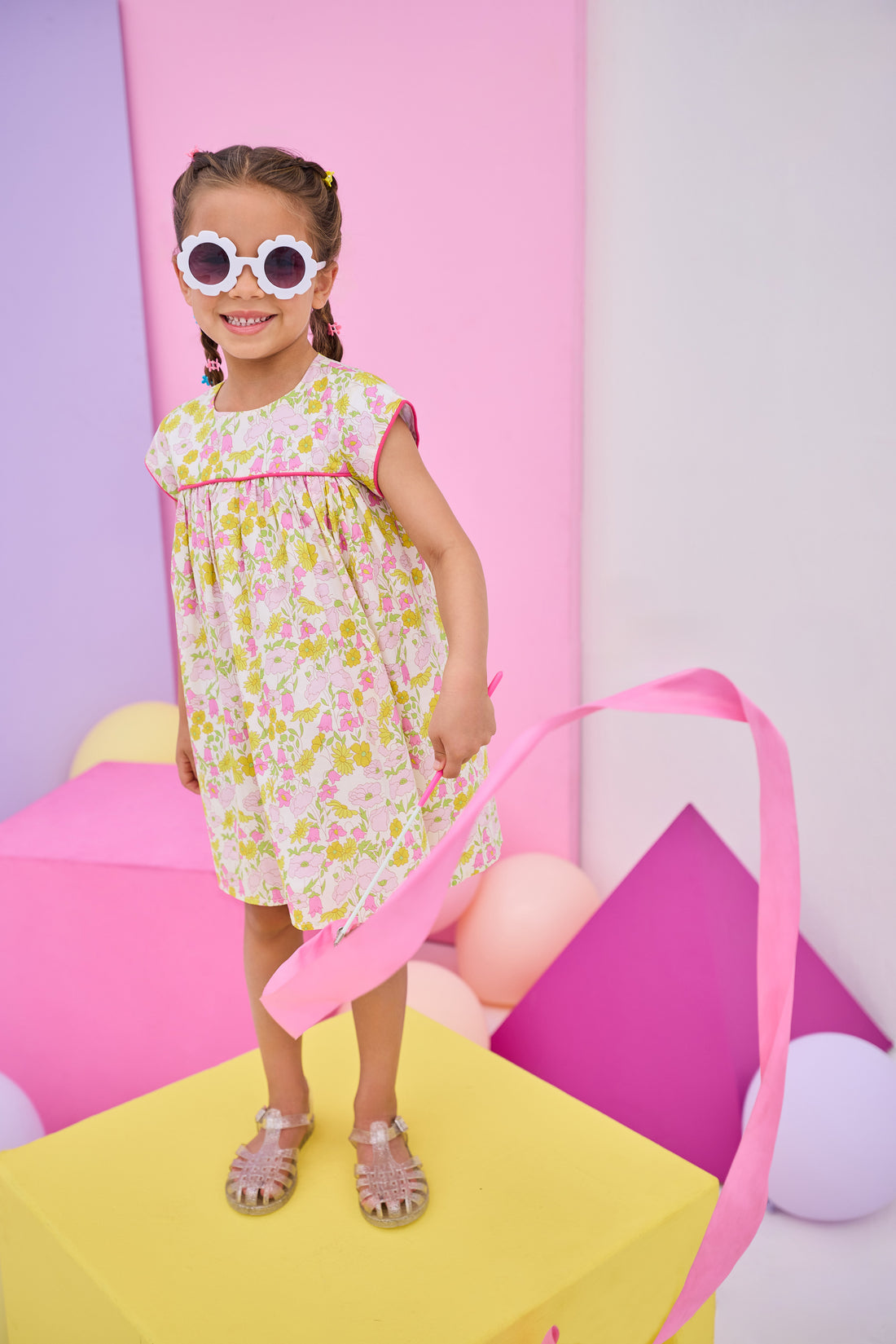Model can be seen wearing yellow/pink floral print that features button closure along back neckline and a beautiful hot pink trim along bust and sleeves to elevate the look. 