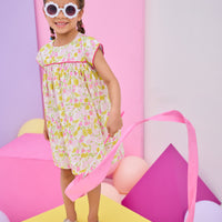 Model can be seen wearing yellow/pink floral print that features button closure along back neckline and a beautiful hot pink trim along bust and sleeves to elevate the look. 