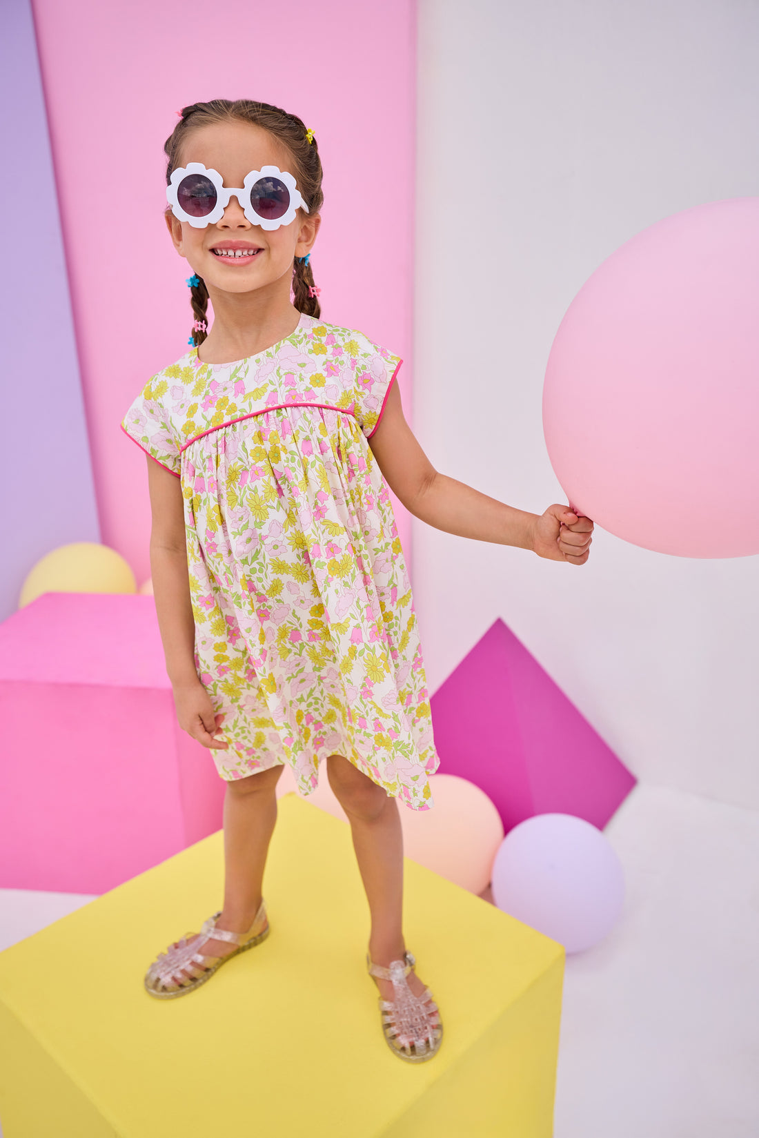 Model can be seen wearing yellow/pink floral print that features button closure along back neckline and a beautiful hot pink trim along bust and sleeves to elevate the look. 