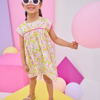 Model can be seen wearing yellow/pink floral print that features button closure along back neckline and a beautiful hot pink trim along bust and sleeves to elevate the look. 