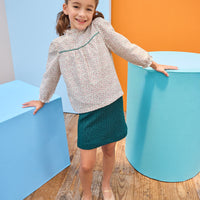 Model can be seen wearing quilted knit emerald green skort that has an elastic waistband and built in shorts for a relaxed but secure fit. Skort pairs back perfectly with woven top in emerald green and red floral to complete the look. 