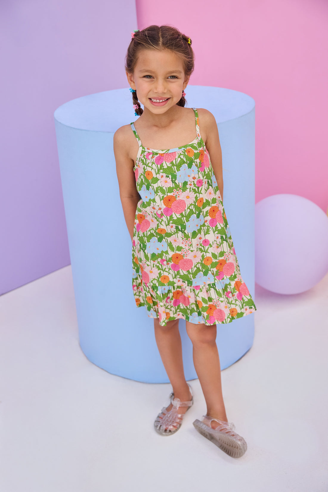 Model can be seen wearing woven strappy dress in a green/orange/pink/light blue floral print. Dress features button closures along back and made of a super soft woven material for a comfy but secure fit. 