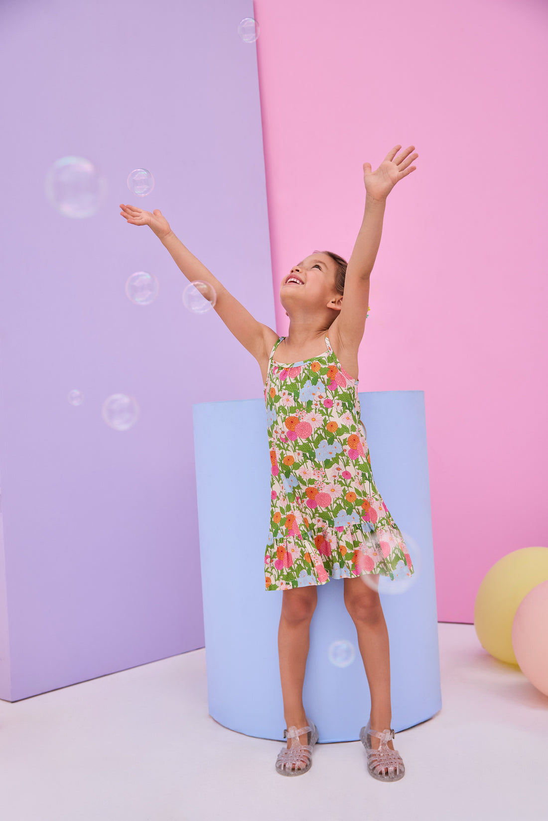 Model can be seen wearing woven strappy dress in a green/orange/pink/light blue floral print. Dress features button closures along back and made of a super soft woven material for a comfy but secure fit. 