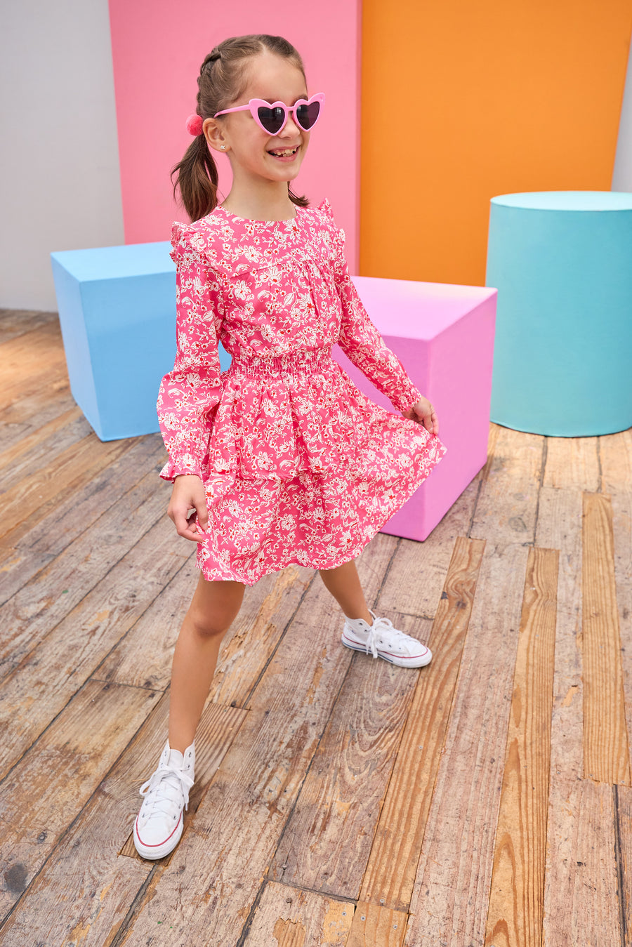 Model can be seen wearing pink/white/red floral woven dress that features an elastic ruched waistband and a two-tiered skirt detail to elevate the dress. 