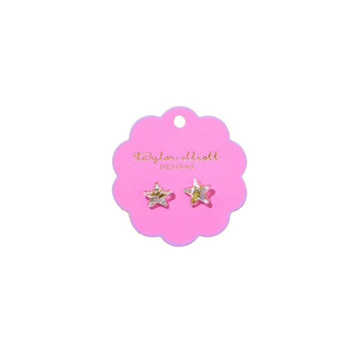 Star-shaped earrings on a pink card.