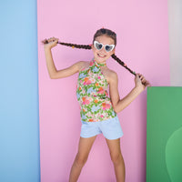 Model can be seen wearing a light blue pair of knit shorts that pair perfectly back with the green/pink/orange/blue floral woven scarf top to complete the look. 