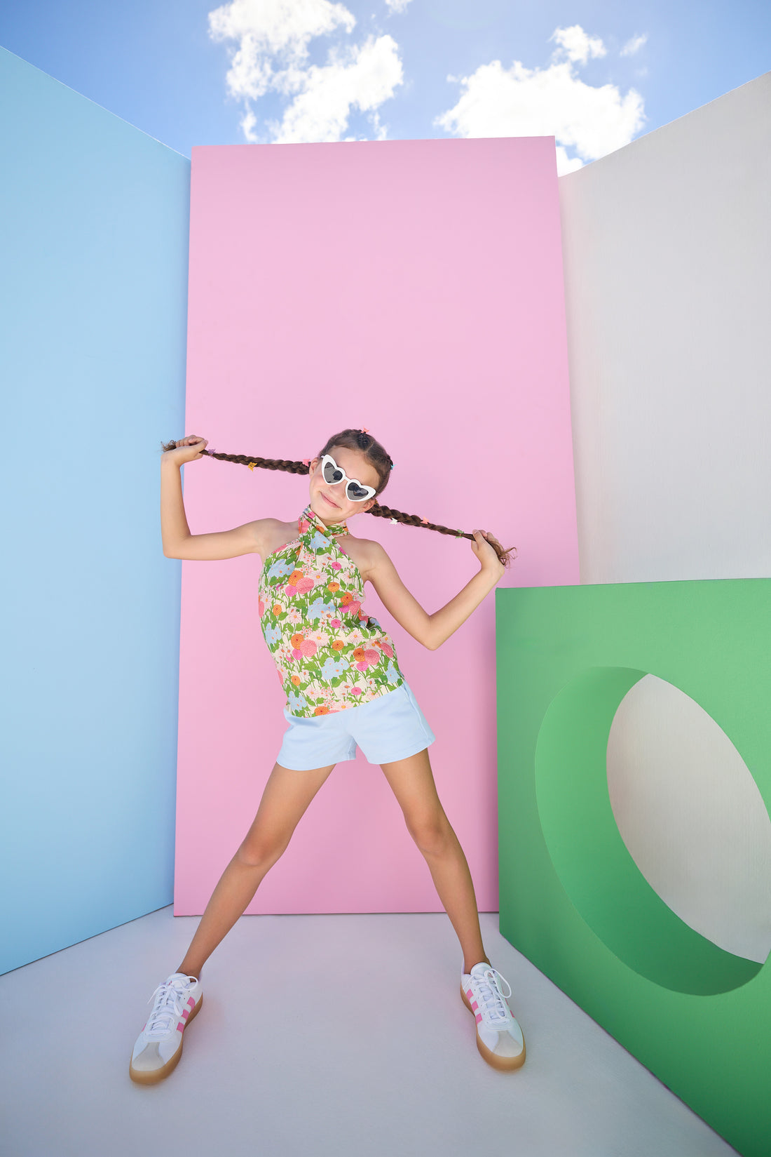 Model can be seen wearing a light blue pair of knit shorts that pair perfectly back with the green/pink/orange/blue floral woven scarf top to complete the look. 