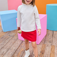 Model can be seen wearing a quilted knit mini skort that features an elastic waistband and built in shorts for a secure but relaxed fit. Pair back perfectly with a white long sleeve  knit top to complete the look. 