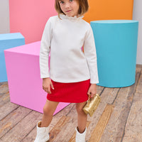 Model can be seen wearing a quilted knit mini skort that features an elastic waistband and built in shorts for a secure but relaxed fit. Pair back perfectly with a white long sleeve  knit top to complete the look. 