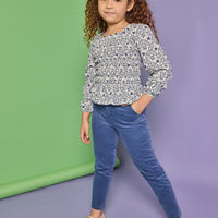 Model can be seen wearing a long sleeve woven top that features elastic ruching throughout the body of the shirt. Made of a blue and white floral print, the top pairs back perfectly with our dusty blue corduroy pants that have two pockets and button closure at waistband. 
