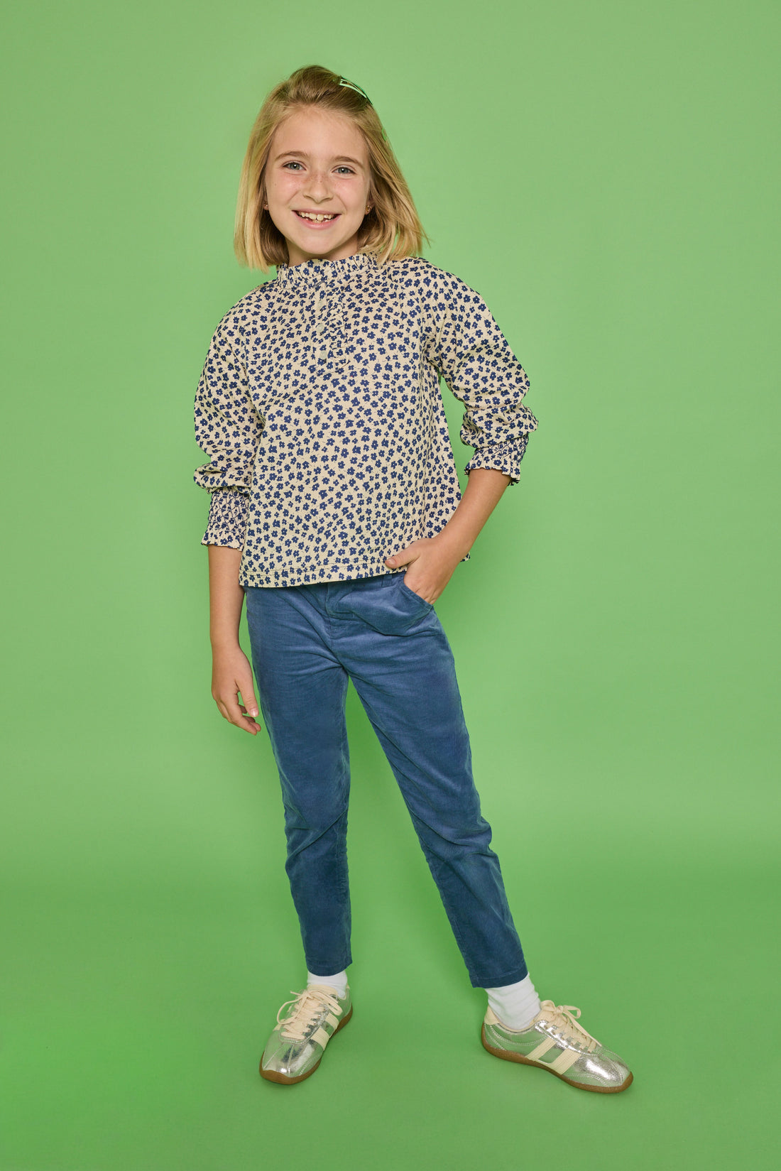 Model can be seen wearing a long sleeve woven top in a blue/cream floral print. Top features button closure packet down bust and smocking detail at sleeves for an elevated look. Paired back with our dusty blue corduroy pants to complete the look. 