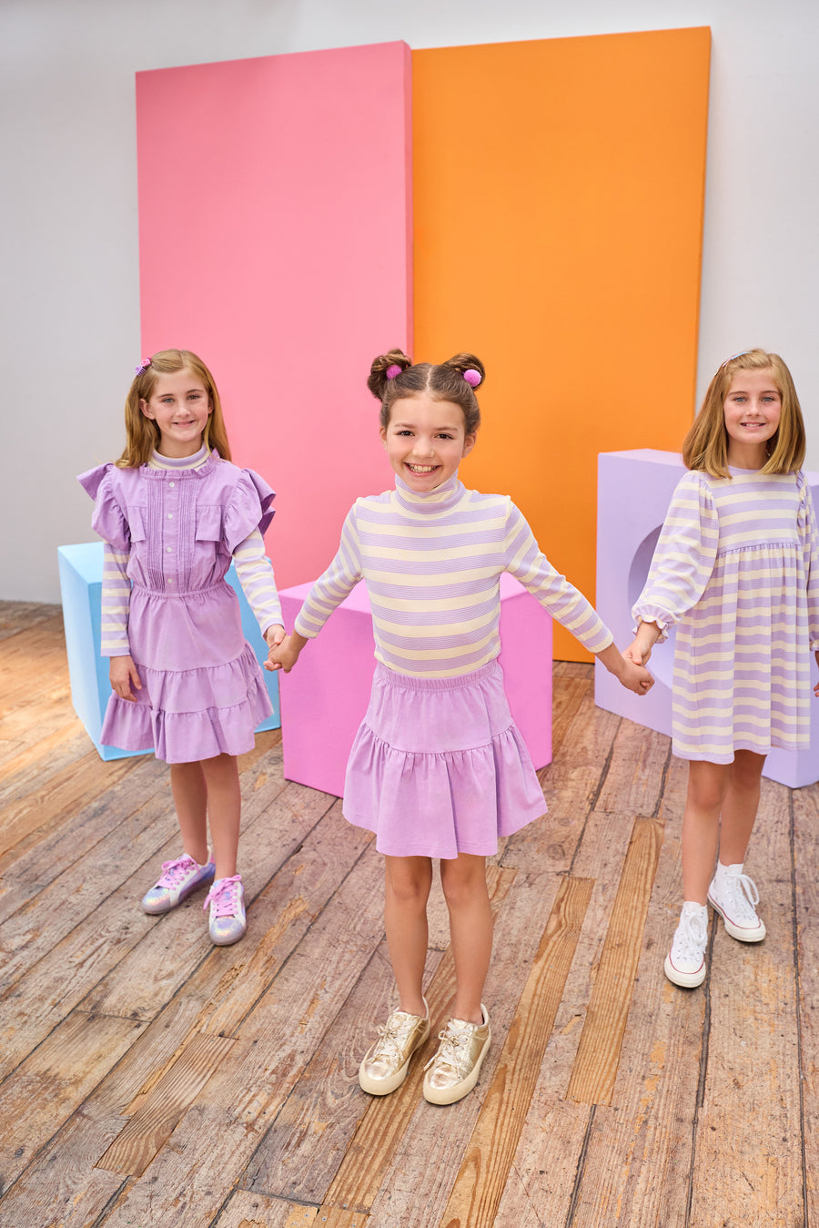 Tween girl in the middle seen wearing a lavender corduroy skirt paired back perfectly with our soft turtleneck in a lavender and cream stripe. Girls on the left and right can be seen wearing similar styles, in the same fabric, for a perfect mix and match.