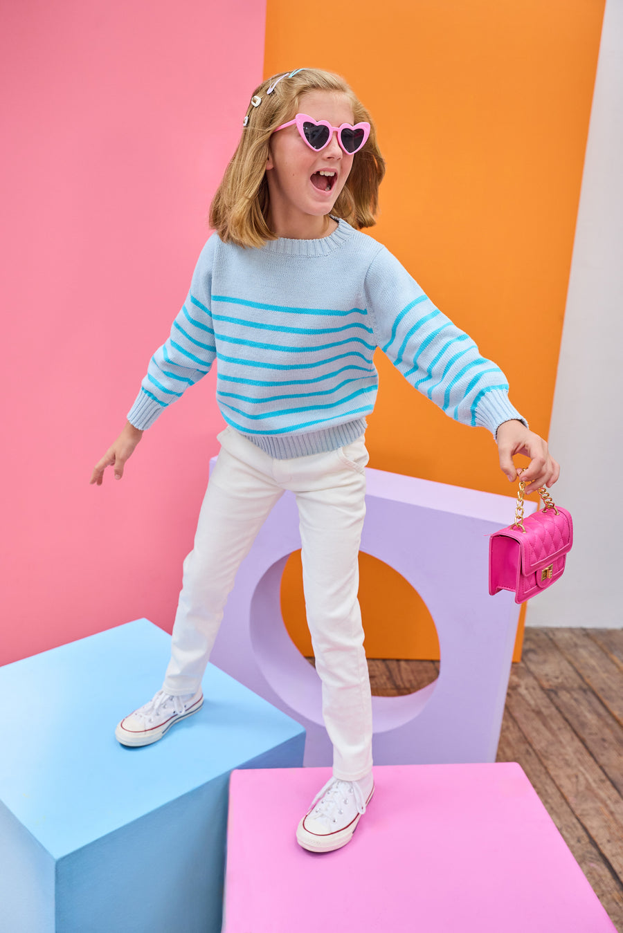 Tween model can be seen wearing a light aqua and turquoise stripe sweater paired back with ivory jeans to complete the look. 