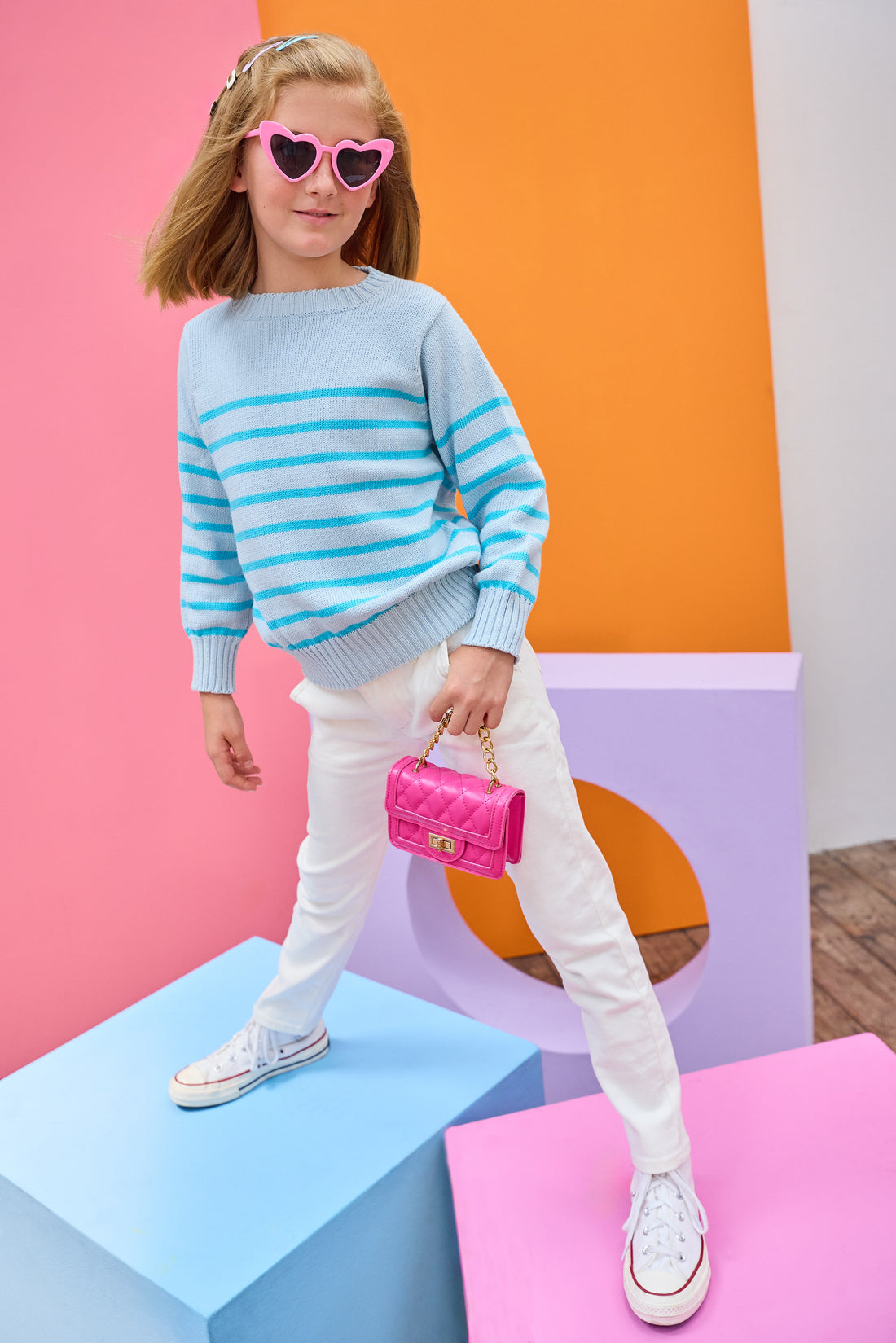 Tween model can be seen wearing a light aqua and turquoise stripe sweater paired back with ivory jeans to complete the look. 